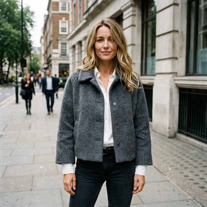 Sidewalk lifestyle photo of a European woman wearing the dark grey jacket